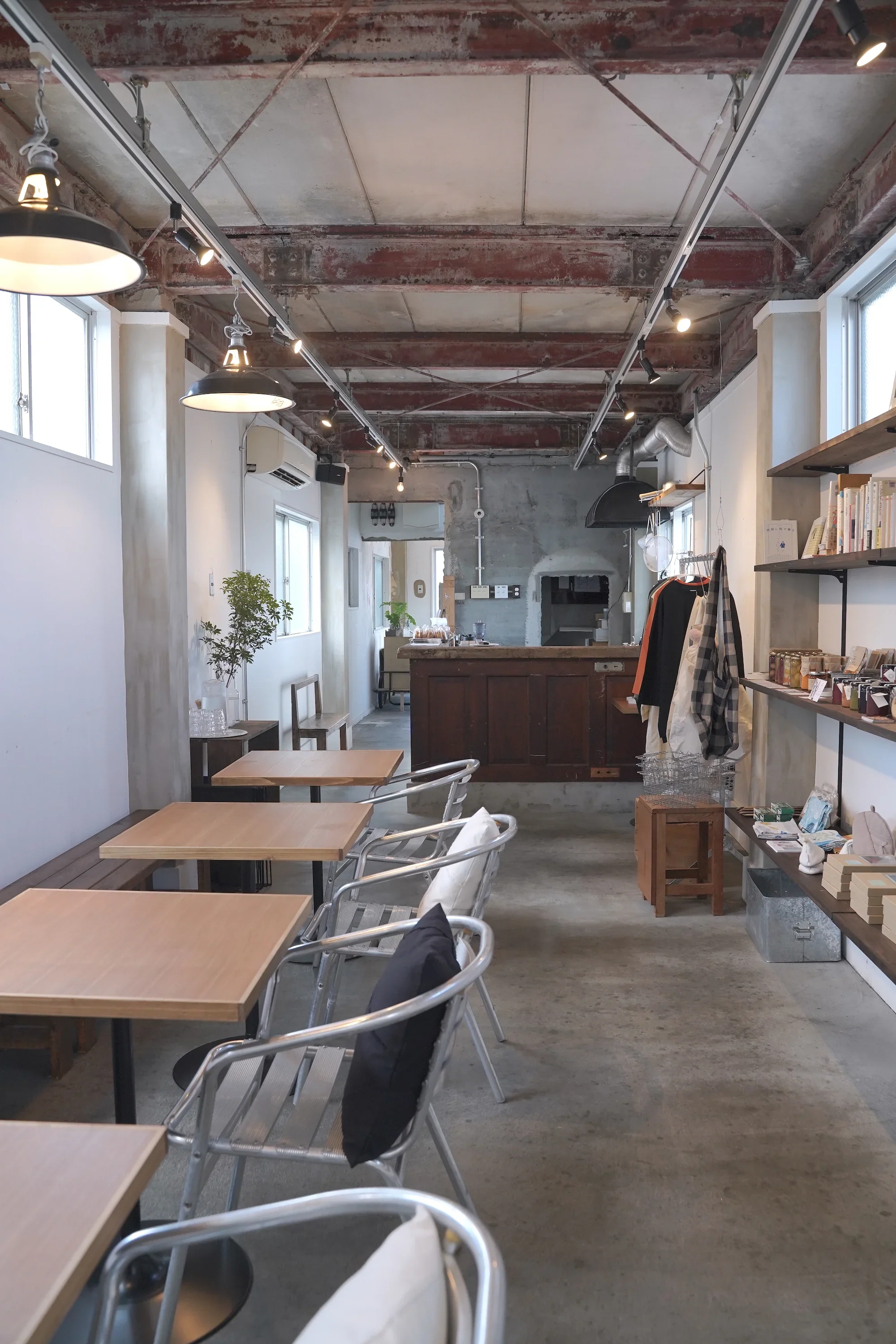 木のテーブルと本棚のあるfuaiの店内